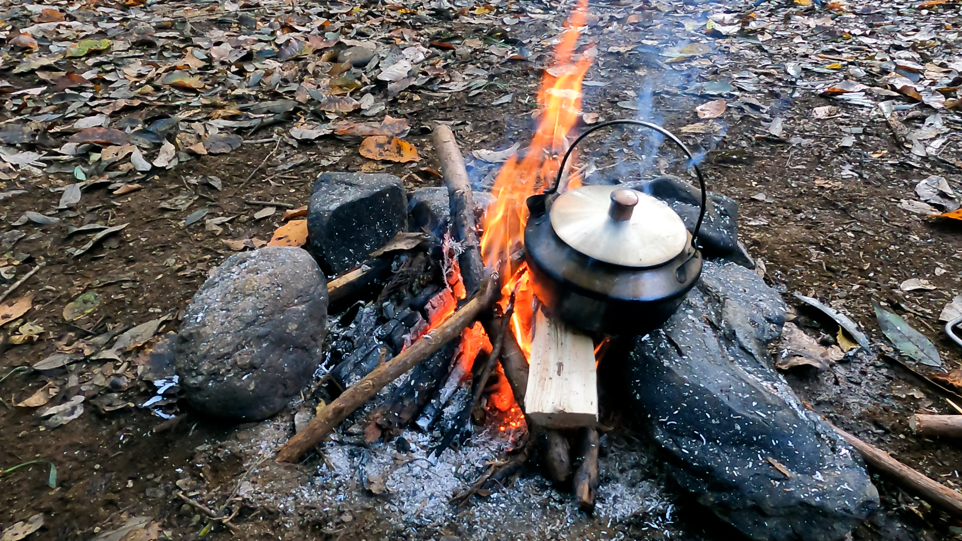 筆者が直火でケトルのお湯を沸かしている。