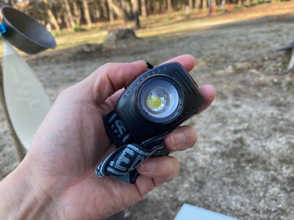 筆者がダイソーのヘッドライト ワイド&スポットを手に持っています。