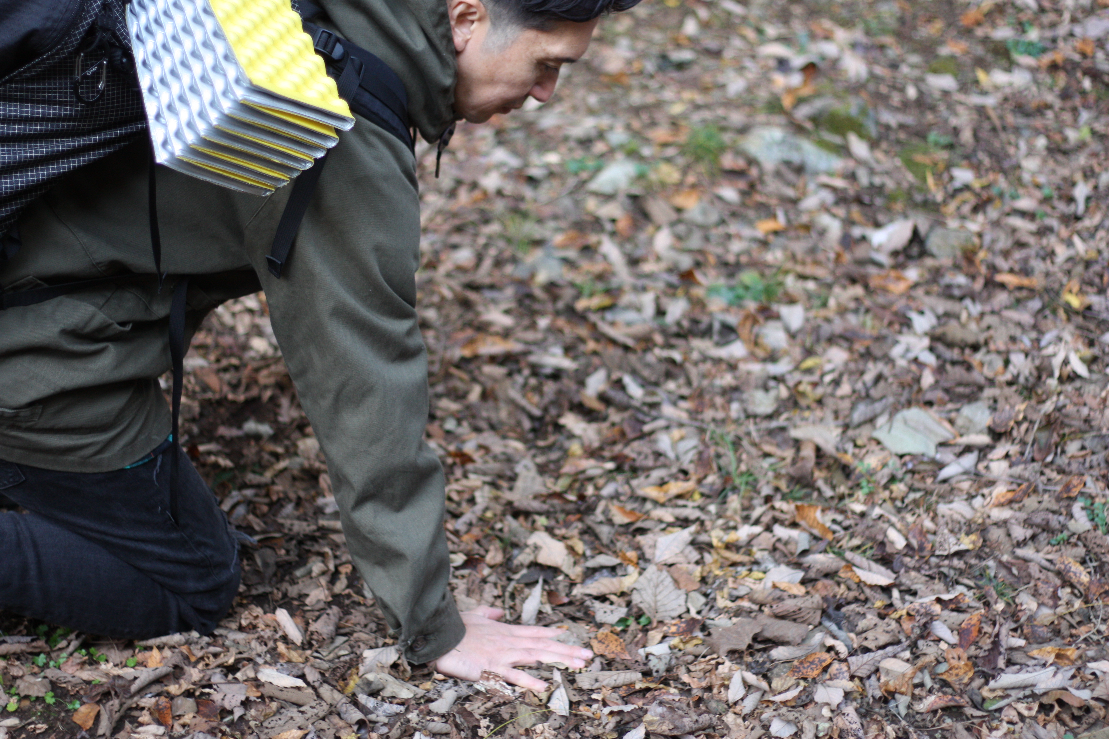 筆者がキャンプサイトの地面のコンディションを確かめている。