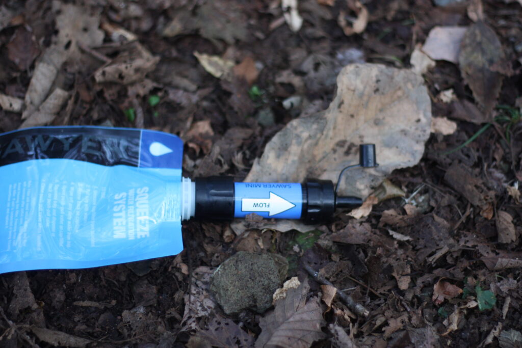 筆者がウォーターバッグに携帯浄水器を取り付けている。