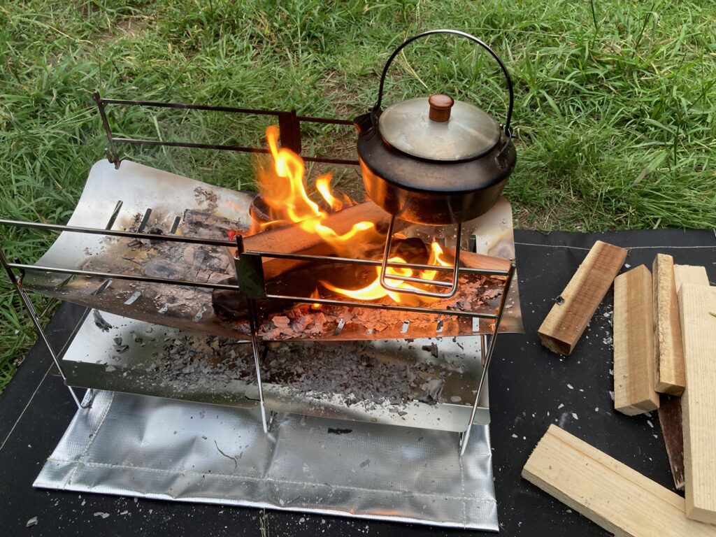 筆者がソロ焚き火台で、ケトルをつかってお湯を沸かしている。