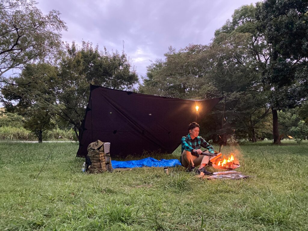 筆者がZENCamps焚き火シートをつかって、ソロキャンプをしている。