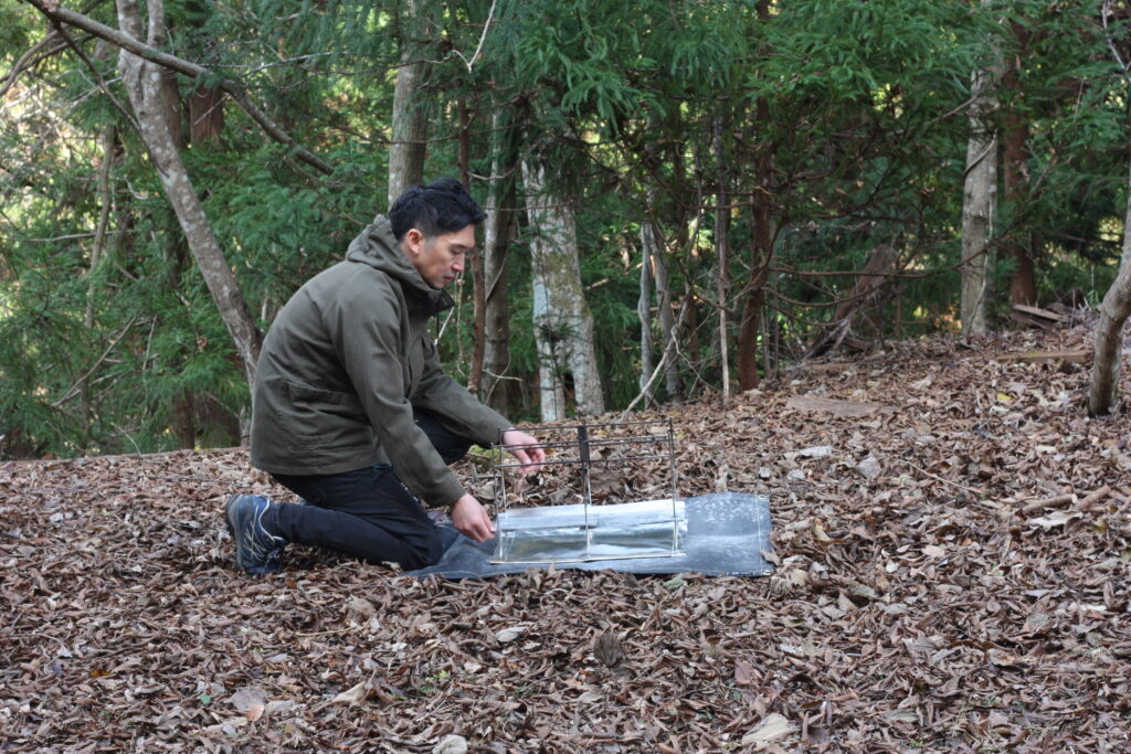 筆者が焚き火台 NT FIRE STANDを組み立てているところ