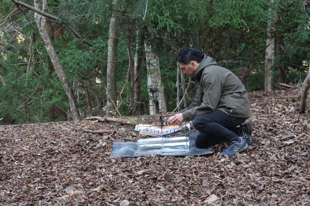 筆者が焚き火台を組み立てている