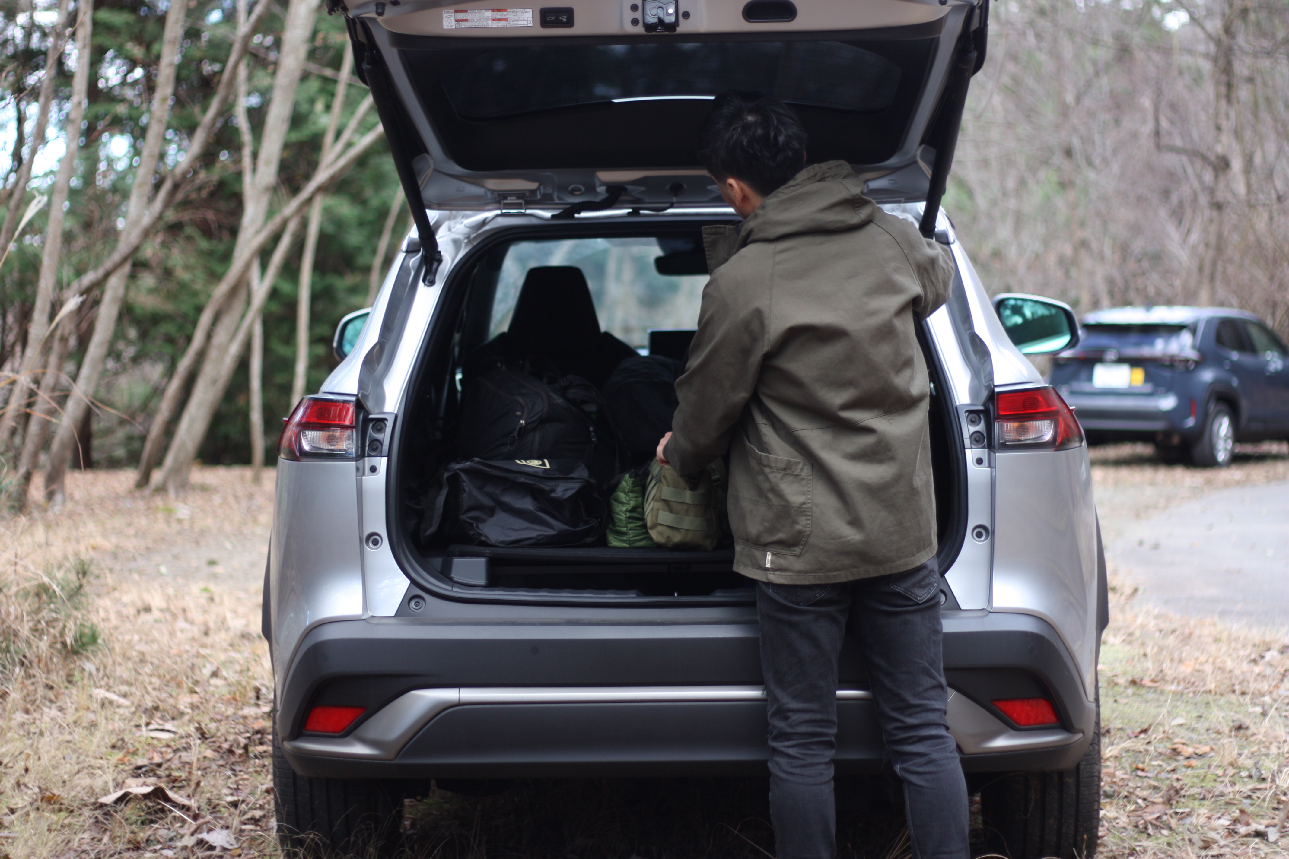 筆者が車にコットなど、キャンプギアを積み込んでいるところ