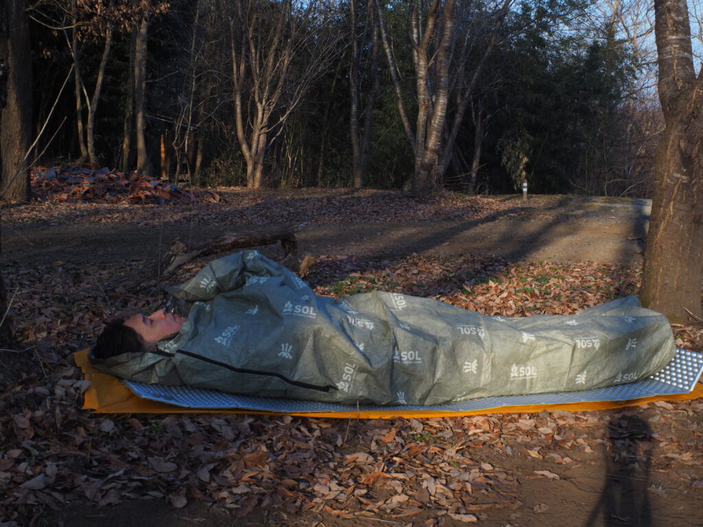 キャンプマットに横になっている筆者