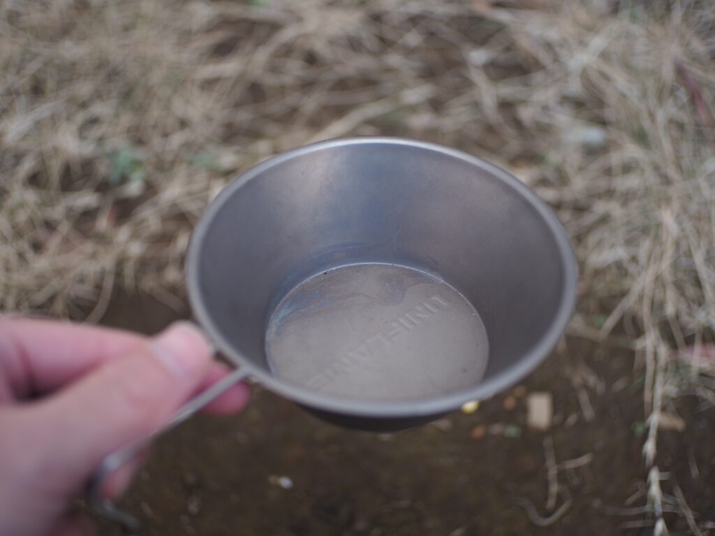 筆者がソロキャンプで、シェラカップを使っているところ